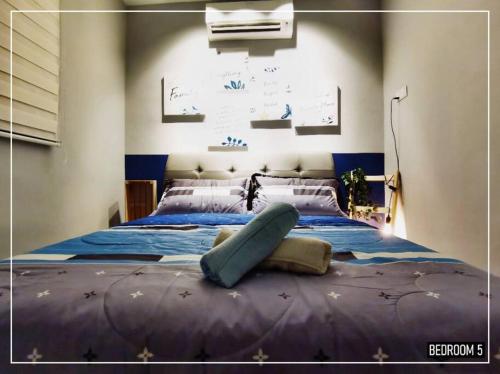 a bedroom with a large bed with blue sheets at 11pax5br Modern 5mins Ipoh Town wPoolTable in Ipoh