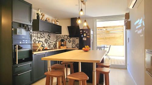 une cuisine avec une table en bois et quelques chaises dans l'établissement --Grui'Zen--, à Gruissan