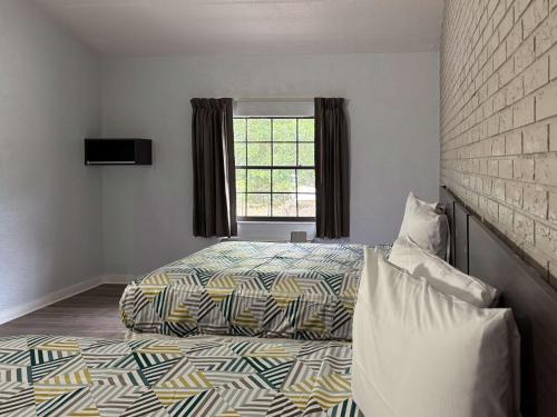 a bedroom with a bed and a window at Motel 6 Tallahassee, FL North Monroe in Tallahassee