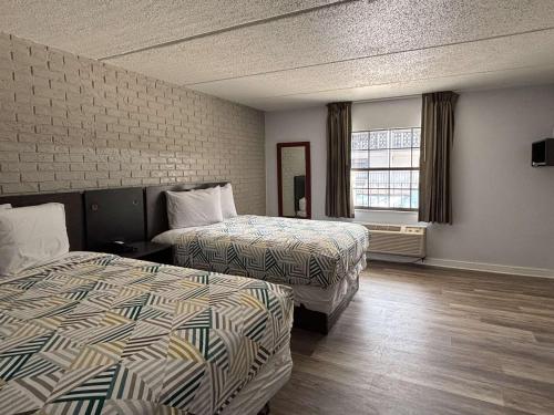 a hotel room with two beds and a window at Motel 6 Tallahassee, FL North Monroe in Tallahassee