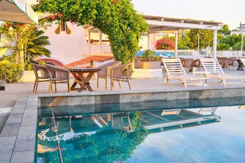 a pool with chairs and a table next to a patio at Av Club Terme Colella in Ischia
