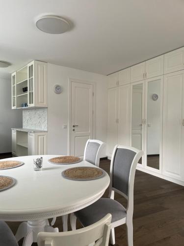 a white dining room with a white table and chairs at Private Trakai Historical Centre Karaim Two Floor Apartment in Trakai