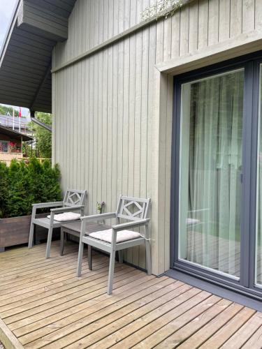 two chairs and a table on a deck at Private Trakai Historical Centre Karaim Two Floor Apartment in Trakai
