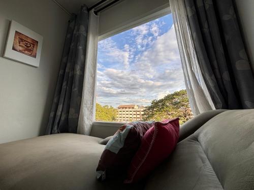a bedroom with a window with a pillow on a bed at Private room hosted by Boyce 415 in Chiang Mai