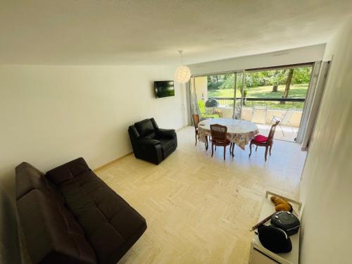 un salon avec un canapé et une table dans l'établissement grand appartement 74m2 refait à neuf à 5mn de la mer dans grand parc botanique, à Villeneuve-Loubet