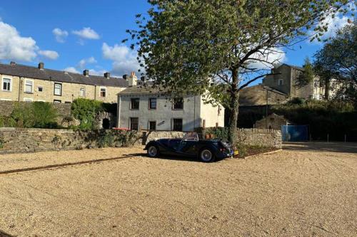 a black car parked in front of a house at Sparks - Turnbridge Guest House in Burnley
