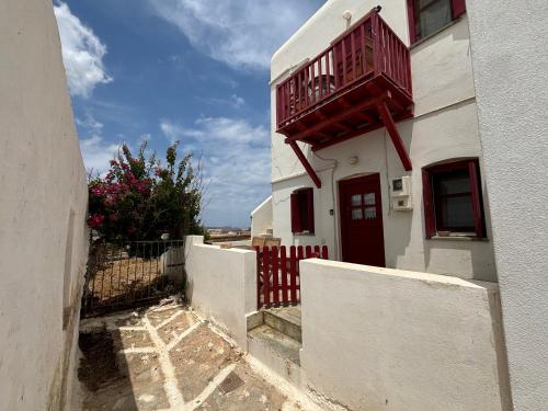 a white building with a red balcony on it at Verantaki in Kithnos