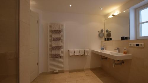 ein Badezimmer mit Waschbecken und Spiegel in der Unterkunft Landhaus Strandhafer HT 1 in Wenningstedt-Braderup