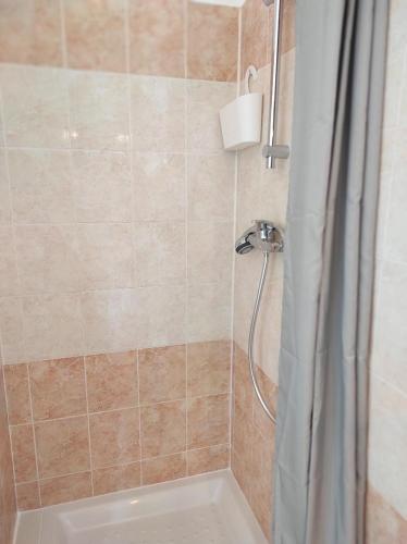 une salle de bain avec une douche avec un rideau de douche dans l'établissement Gîte Le Jasmin, à Saint-Andiol