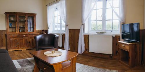 a living room with a tv and a table at Hotel Ekke Nekkepenn in Nebel