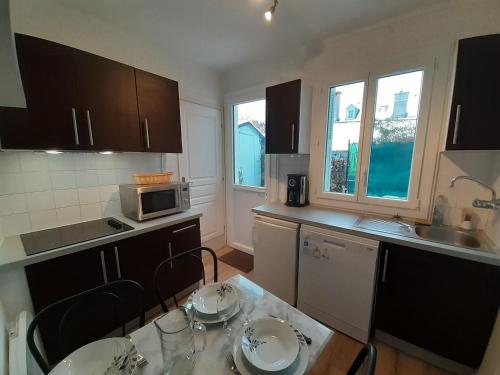 une petite cuisine avec une table et un micro-ondes dans l'établissement Appartement Confortable, à Argelès-Gazost