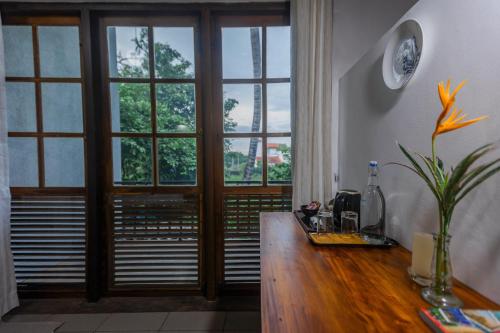 a room with a wooden table with a large window at The Fern Cove Villa - Colombo in Battaramulla