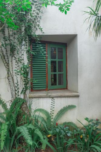 a window with a green shutter on a building at The Fern Cove Villa - Colombo in Battaramulla