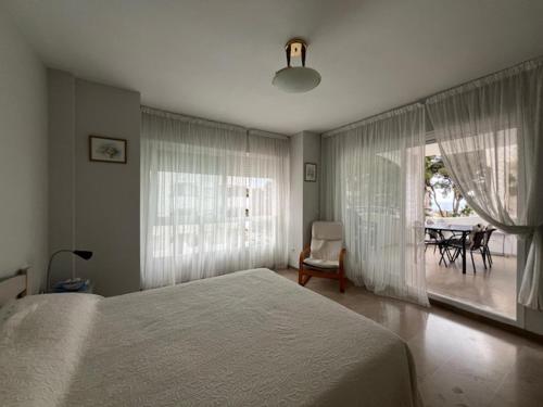 a bedroom with a bed and a chair and a table at Puerto Marina in Benalmádena