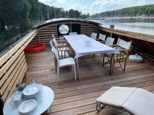 a wooden deck with tables and chairs on a boat at Hausboot vom Feinsten in Berlin