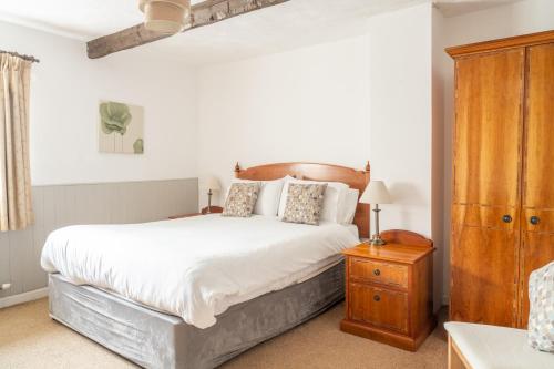 a bedroom with a large bed with a wooden headboard at The Lordleaze Hotel And Restaurant in Chard
