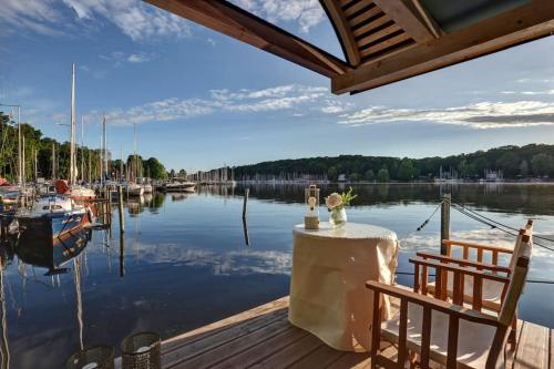 a table and chairs on a dock next to the water at Hausboot vom Feinsten in Berlin