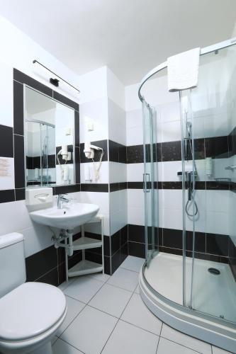 a bathroom with a toilet and a sink and a shower at Medos Hotel in Budapest