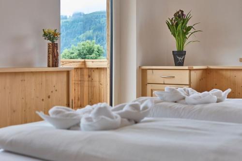 two beds with white towels on them in a room with a window at Platzhirsch Rooms - B&B - SELF CHECK-IN in Piesendorf