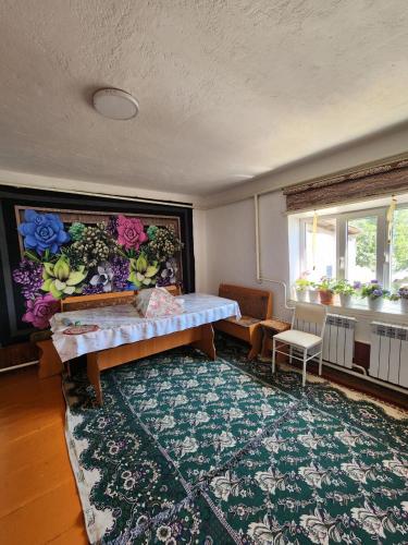 a living room with a table and a rug at Guesthouse Koguchkon in Kara-Talaa