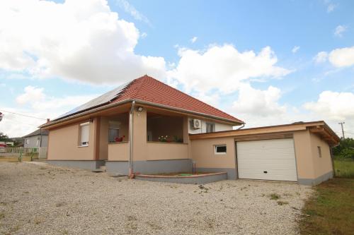 a house with a garage in front of it at Tulipán Vendégház in Polány