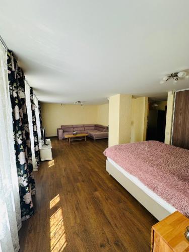 a room with a bed and a couch in it at Rožu namu apartamenti in Kuldīga