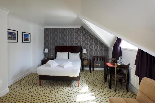 a hotel room with a bed and a staircase at Basingstoke Country Hotel & Spa in Hook