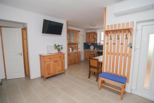 a kitchen with a table and a tv on the wall at Tulipán Vendégház in Polány