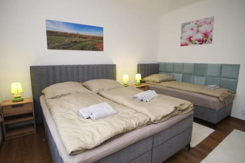 a bedroom with two beds with towels on them at Tulipán Vendégház in Polány