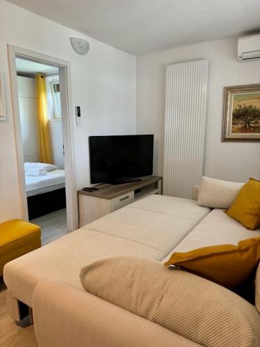 two beds in a room with a tv and a bedroom at Apartment Malija Cikloped in Izola