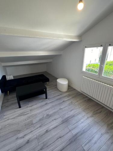 une chambre avec un banc, une table et deux fenêtres dans l'établissement Duplex cosi, à Pierrefitte-sur-Seine