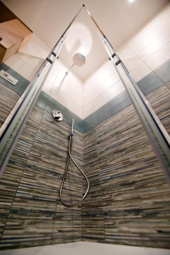 a shower with a glass door with a shower head at IRTO B&B in Castellammare di Stabia