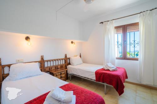 a bedroom with two beds and a window at Casa Horizonte in Moraira