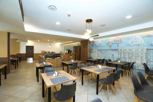 a restaurant with tables and chairs and a cafeteria at Medos Hotel in Budapest