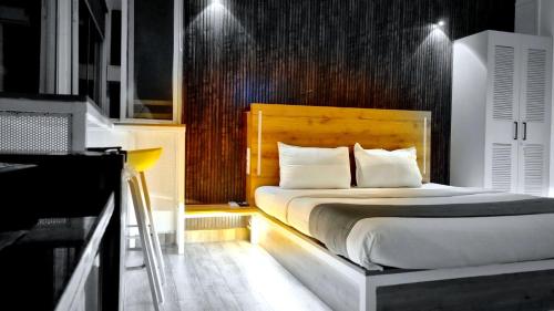 a bedroom with a bed with a wooden headboard at Stayinn Nest in Bhopal