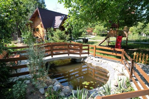 a wooden bridge over a pond in a garden at Casa Stefandra in Breaza