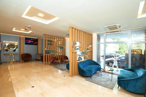 a living room with a blue couch and chairs at Medos Hotel in Budapest