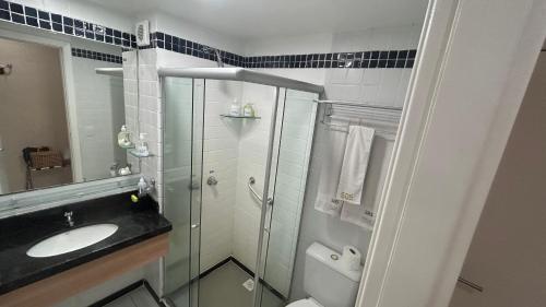 a bathroom with a sink and a toilet and a mirror at Mar de Ponta Negra in Natal