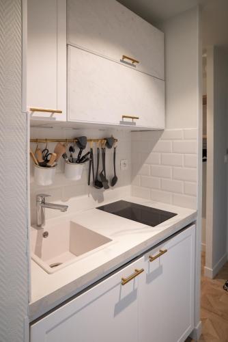 une cuisine avec des armoires blanches et un évier dans l'établissement Gite 