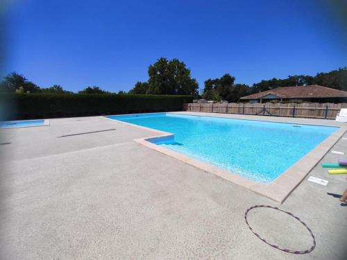 une grande piscine avec de l'eau bleue dans l'établissement Mobilhome Cocooning, à Mimizan