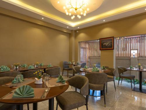 a restaurant with tables and chairs and a chandelier at Hotel Samye - Best Hotel In Thimphu in Thimphu