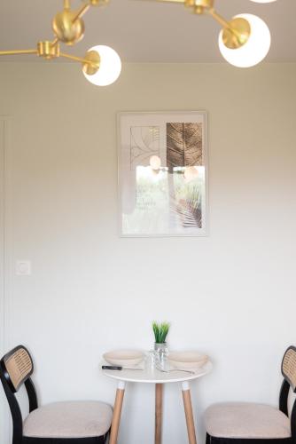 une table et des chaises dans une pièce dotée d'un lustre dans l'établissement Gite 