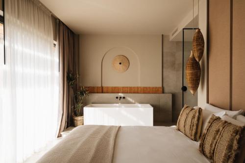 a bedroom with a bed and a sink and a tub at Noctis Hotel in Soria
