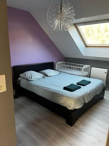 - une chambre avec un grand lit et un lustre dans l'établissement La Casa d'Alicia - Maison avec vue, à Monthermé