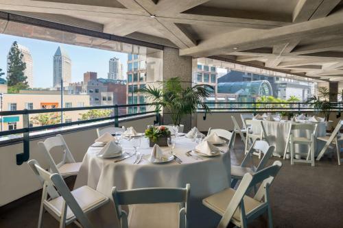 a room with white tables and chairs and a balcony at The Westin San Diego Bayview in San Diego