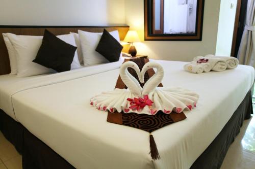 a bed with two swans made out of towels at Rapeepan Ville Hotel in Ubon Ratchathani