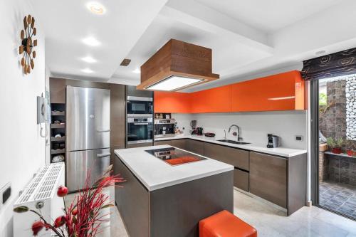 a large kitchen with orange and silver appliances at Veranna Lux Apartment in Ialyssos