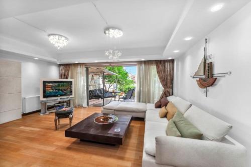 a living room with a couch and a table at Veranna Lux Apartment in Ialyssos