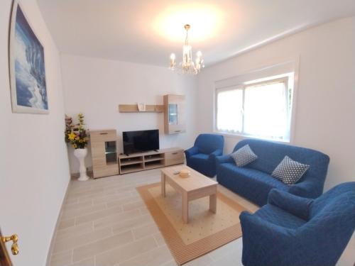 a living room with a blue couch and a table at Apartamento Lago Pereira in Muxia