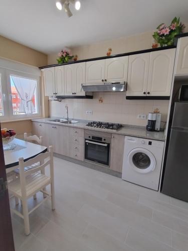 a kitchen with white cabinets and a stove top oven at Apartamento Lago Pereira in Muxia
